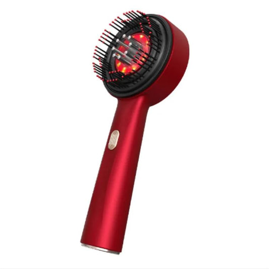 The Scalp Comb vibrating massage comb with its warm red light on