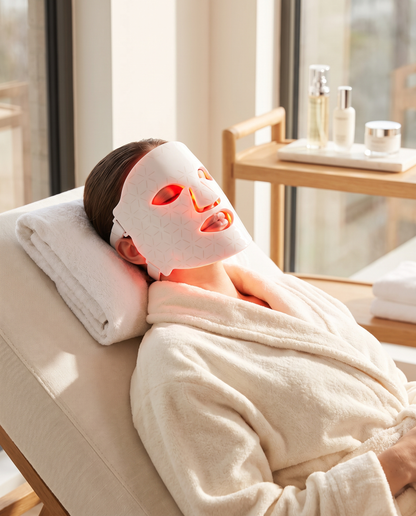 Woman relaxing wearing the glowing red Glow Mask LED face mask