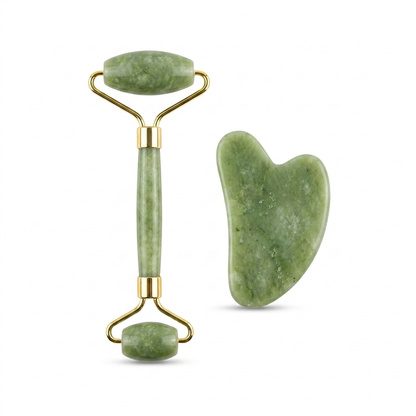 The jade roller and gua sha stone on a pale background